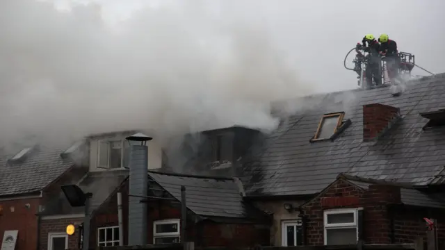 Firefighters above the roof