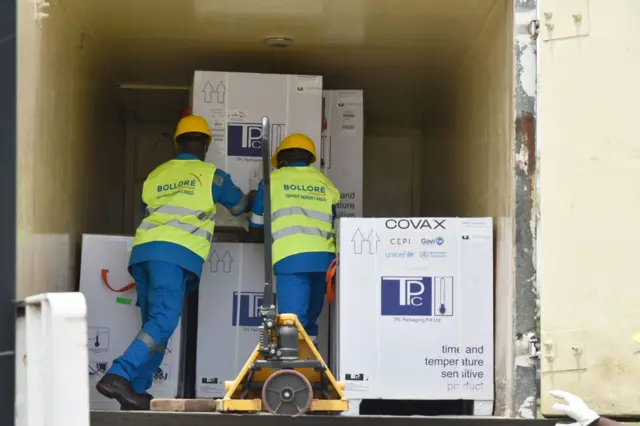 Workers load a shipment of AstraZeneca Covid-19 vaccine in Abidjan