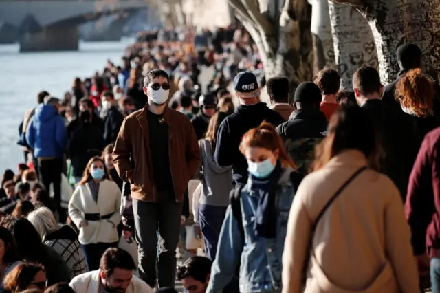 Pedestrians walk by the river Seine in Paris on 28 February