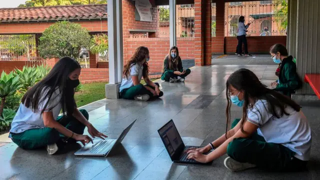 Children working on laptops socially distanced