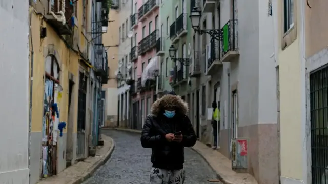 A person wearing a protective mask walks in Bairro Alto neighborhood during the national lockdown in Lisbon, Portugal, 23 January 2021