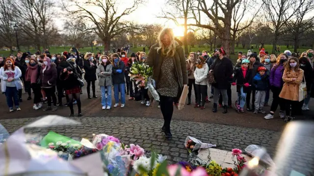 A woman laying flowers at the vigil