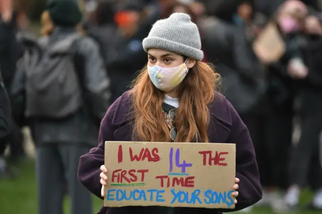 Woman holding a cardboard sign