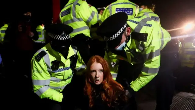 A woman being detained by police at Clapham Common