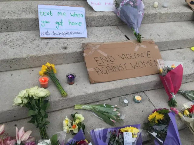 Signs and flowers at vigil at Millennium Square in Leeds