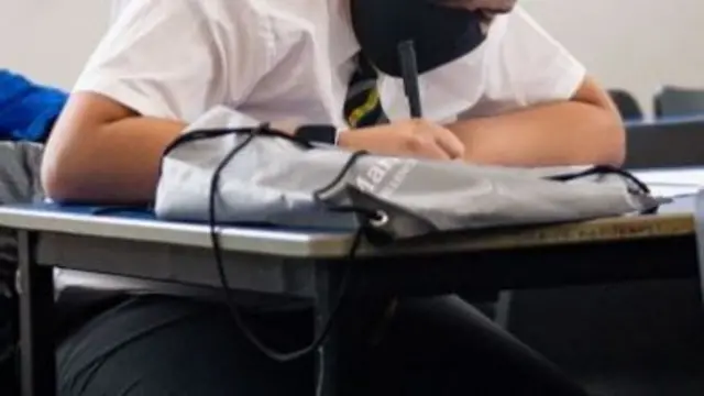 Pupil in mask at desk