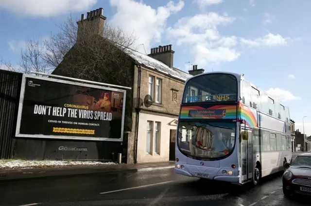 Bus and coronavirus message on billboard