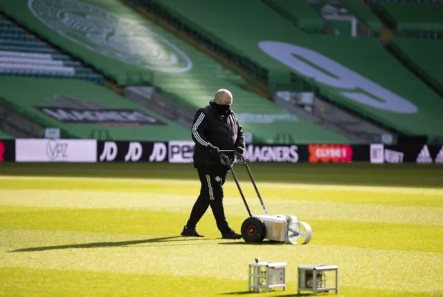 The sun is out and the pitch at Celtic Park gets a touch up from groundstaff