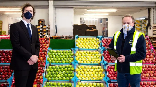 2 people stood by market stall with ipad