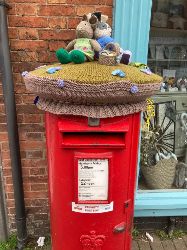 Easter themed post box topper on High Street in Syston, Leicestershire