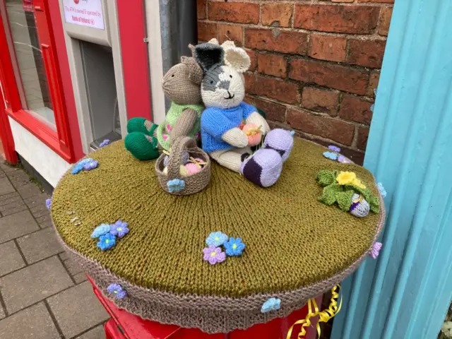 Easter themed post box topper on High Street in Syston, Leicestershire