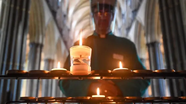 A vicar looking at a candle