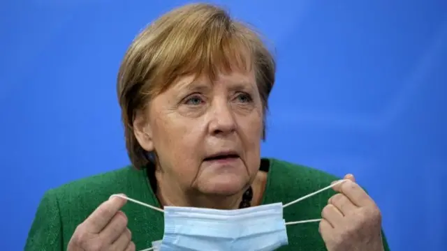 German Chancellor Angela Merkel holds a mask at a news conference after a meeting with state leaders to discuss options beyond the end of the pandemic lockdown, amid the outbreak of the coronavirus disease (COVID-19), in Berlin, Germany, March 23, 2021