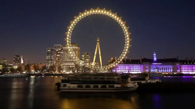 London Eye is illuminated in yellow, as part of a day of reflection to mark the anniversary of Britain"s first coronavirus disease (COVID-19) lockdown, in London, Britain March 23, 2021.