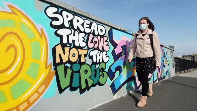 Woman walks past mural