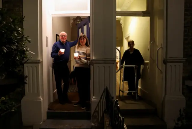 Three people on their doorsteps in Fulham, west London