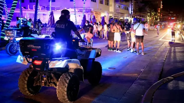 Miami Beach police officers enforce an 8pm curfew imposed by local authorities on spring break festivities, amid the coronavirus disease (COVID-19) pandemic, in Miami Beach, Florida,