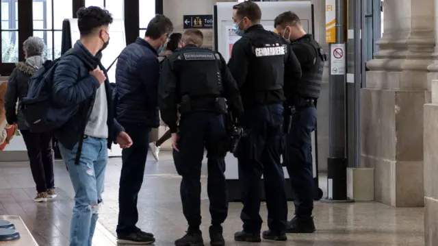 Policemen control travellers on the platform of Saint-Jean train station in Bordeaux, France, 27 March 2021. French Prime Minister Castex on March 18 announced additional lockdown restrictions in 16 regions of France as the country enters a third wave of the COVID-19 pandemic.