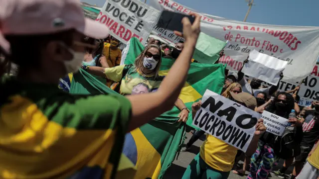 Several people protest against the new measures implemented to stop the spread of covid-19, on the beach of Copacabana, in Rio de Janeiro, Brazil,