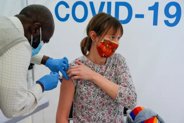 A woman receives a dose of Covid vaccine at a centre at Newmarket Racecourse