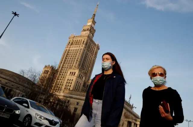 People wear masks in Warsaw