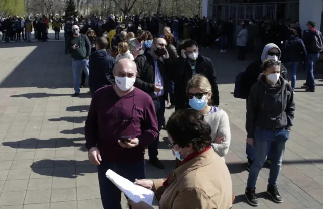 People wait in line in front of a vaccination centre in Belgrade