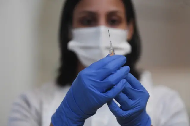 Woman with vaccine vial