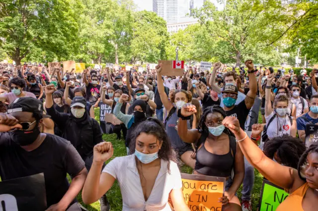 Protesters wearing face masks hold up their fists during the demonstration