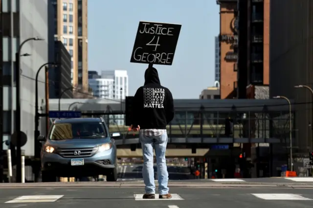 A demonstrator blocks traffic outside the Hennepin County Government Center