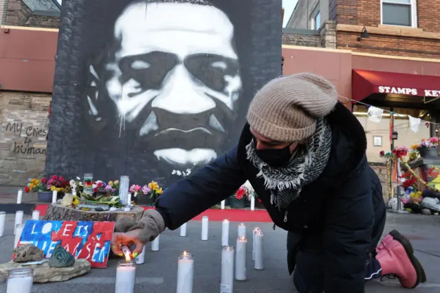 Community activists light candles at a memorial near the site where George Floyd died