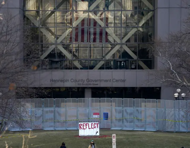 A mirror with a rose on it, part of an art installation by Visual Black Justice, is visible outside the Hennepin County Government Center