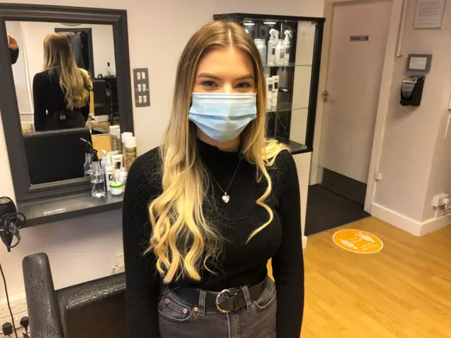Elle Byatt wears a mask in the salon where she works