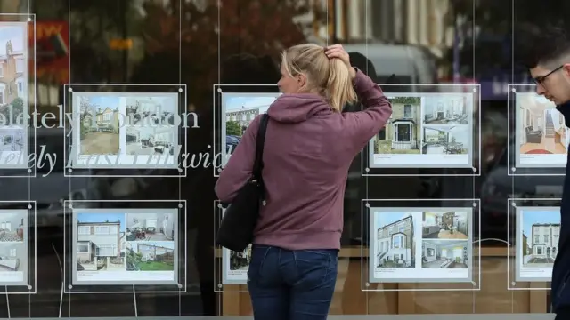 Woman at estate agent window