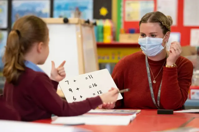 Teacher wearing a mask and pupil