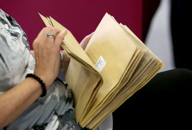 A woman holding exam result letters