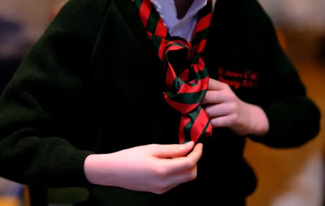 Child putting on a school tie