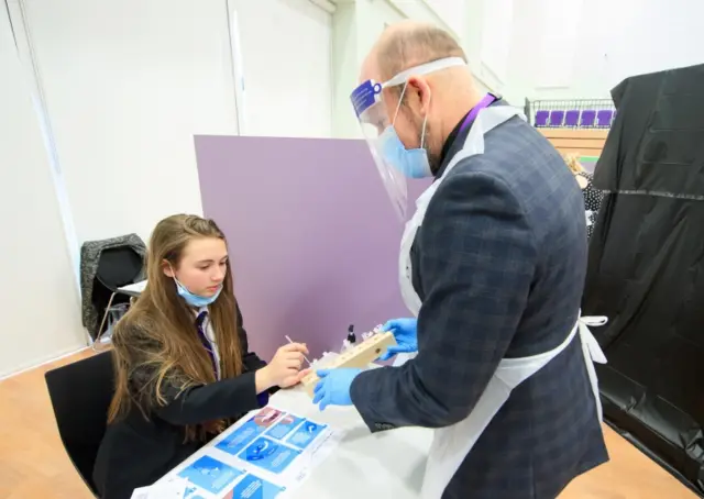 School staff help pupils take lateral flow Covid tests