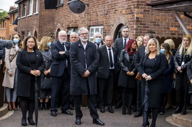 Mary Lou McDonald, Gerry Adams, Michelle O'Neill and other mourners outside the home of Bobby Storey on the day of his funeral