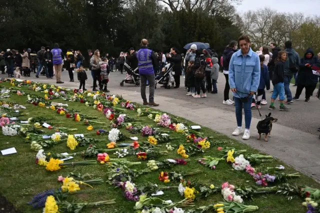 People lay flowers outside Windsor Castle, a day after the passing of Britain's Prince Philip, in Windsor, on 10 April 2021