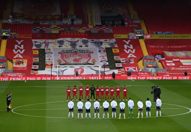 Liverpool and Aston Villa players and match officials  stand in silence