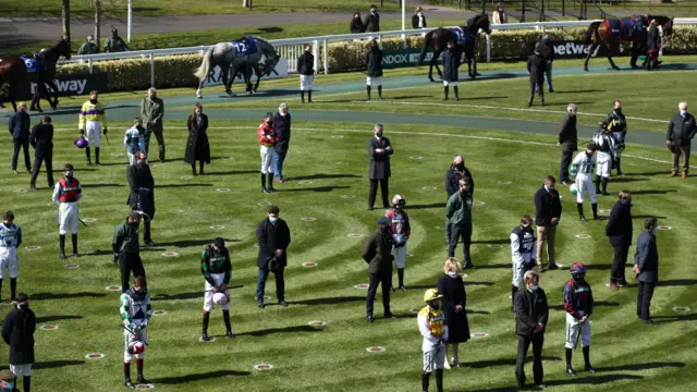 Racegoers and riders observe a two-minute silence for the late Prince Philip, Duke of Edinburgh, before the Pertemps Network Handicap Hurdle during Ladies Day of the 2021 Randox Health Grand National Festival at Aintree Racecourse, Liverpool.