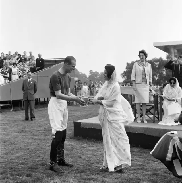 The Maharani of Jaipur presents Prince Philip with the Victoria Cup when his team Windsor Park beat Friar Park at Polo at Windsor Great Park in May 1960