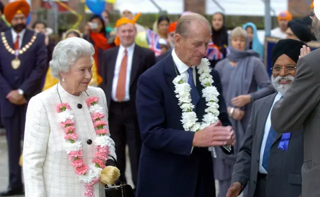 The Queen and Duke of Edinburgh wear wreaths on a visit to Gurdware Sri Singh Sabha Temple in Hounslow, west London