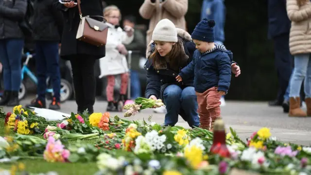 A woman and child leave flowers outside Windsor Castle