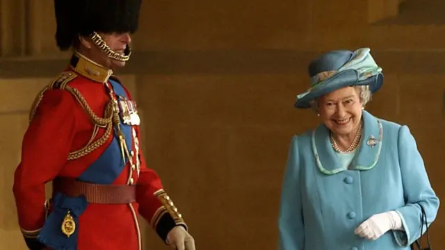 The Duke of Edinburgh in uniform next to a smiling Queen