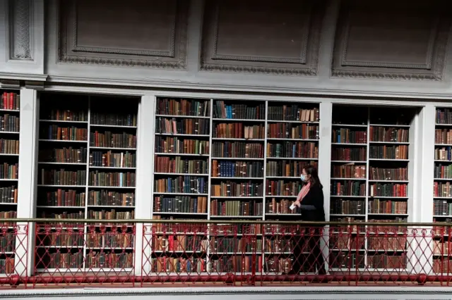 Woman looks at shelves of books