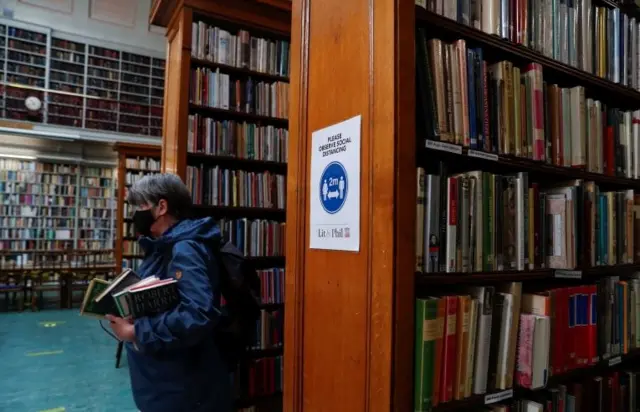 Member waits with a number of books