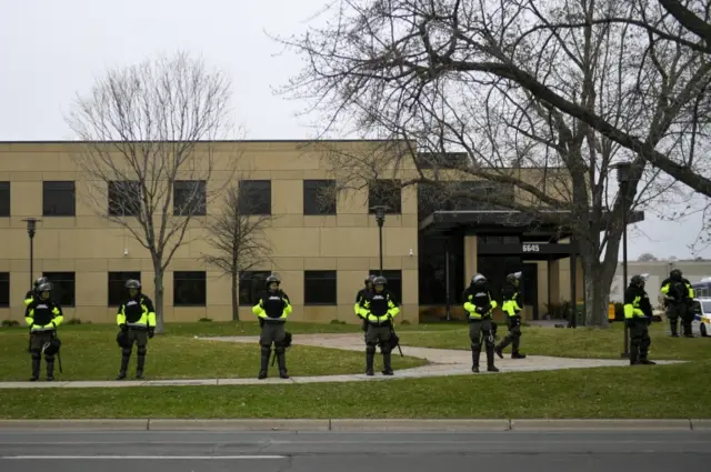 Police and the National Guard stand outside the Brooklyn Center Police Department