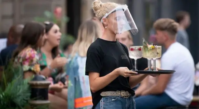 A woman carries a tray of drinks