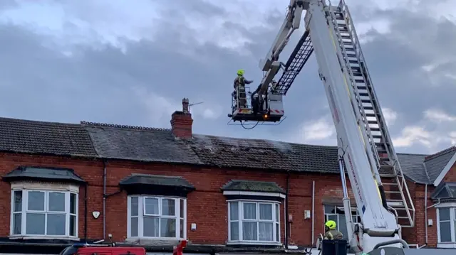 Firefighter examining the roof of the building